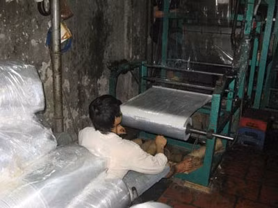 Công nhân điều khiển máy thổi túi nilon miệt mài Công nhân điều khiển máy thổi túi nilon miệt mài