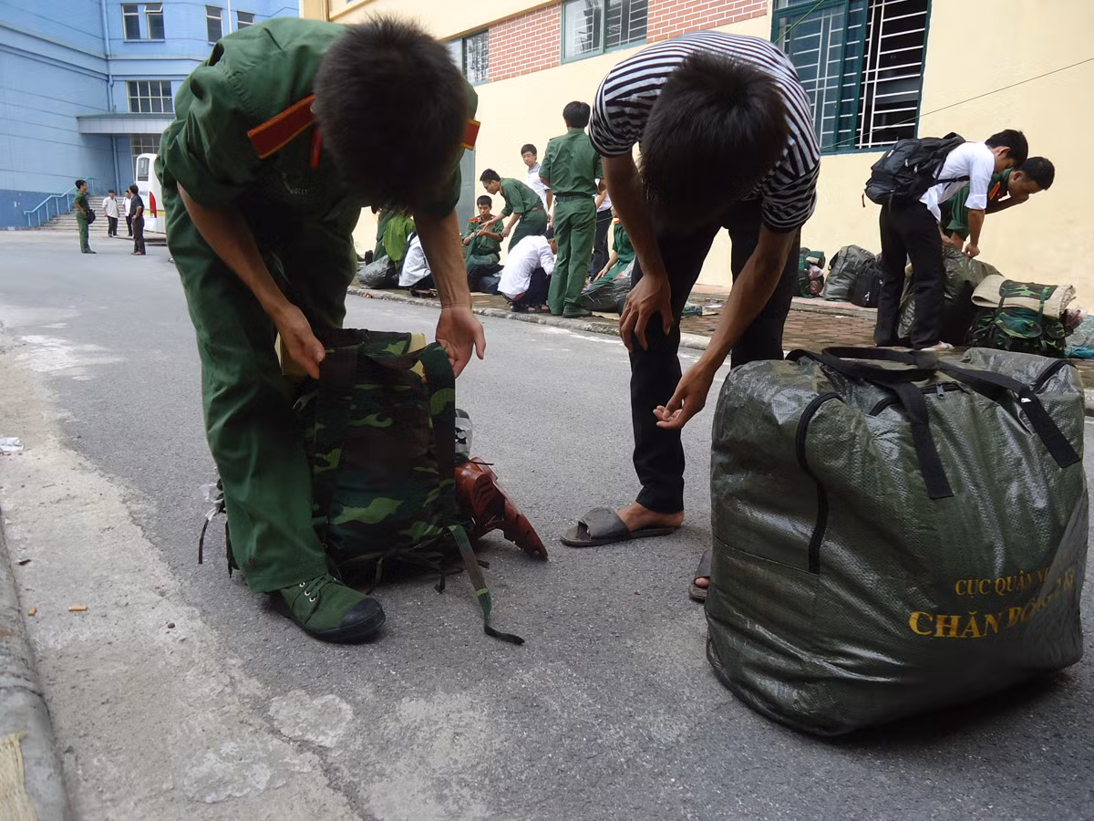 Anh chị học viên khóa trên đang hướng dẫn các em học viên khóa mới cách gói buộc ba lô.