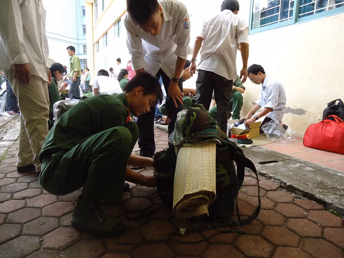 Anh chị học viên khóa trên đang hướng dẫn các em học viên khóa mới cách gói buộc ba lô.