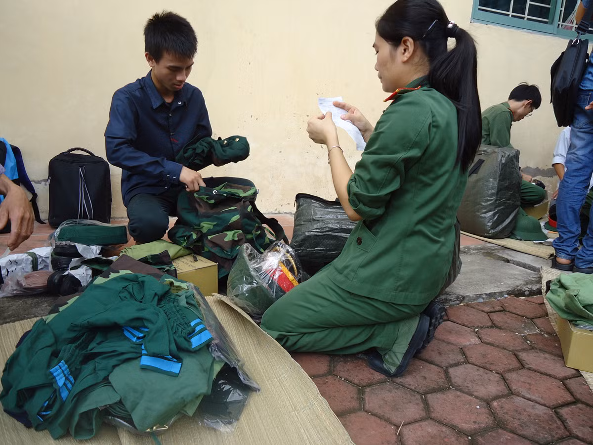 Anh chị học viên khóa trên đang hướng dẫn các em học viên khóa mới cách gói buộc ba lô.
