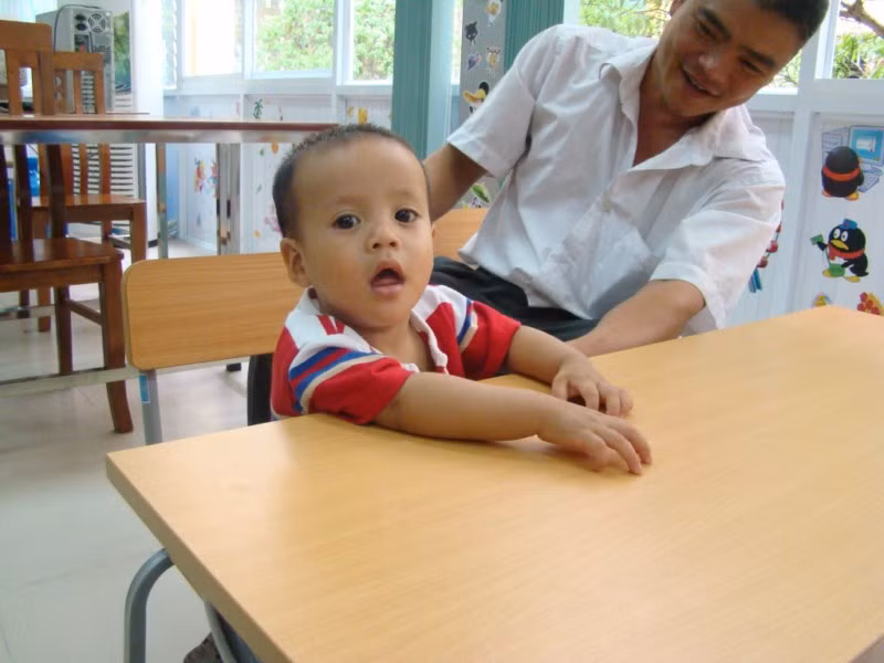 Cậu bé 15 tháng cũng theo anh chị lớn xuống lớp học
