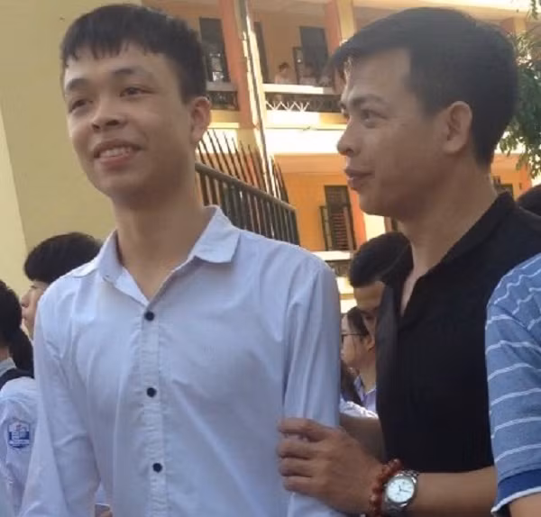 Cảm động ông bố nắm tay con trai động viên, an ủi và vỗ về con trai sau khi thi xong môn Toán rằng: “không sao đâu, đó chỉ là một bài thi”. Ảnh: Công Tiến