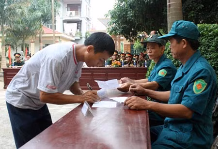 Quân nhân dự bị của xã Thanh Vân, huyện Tam Dương, tỉnh Vĩnh Phúc trình lệnh gọi động viên tại UBND xã, chuẩn bị lên đường nhập ngũ.