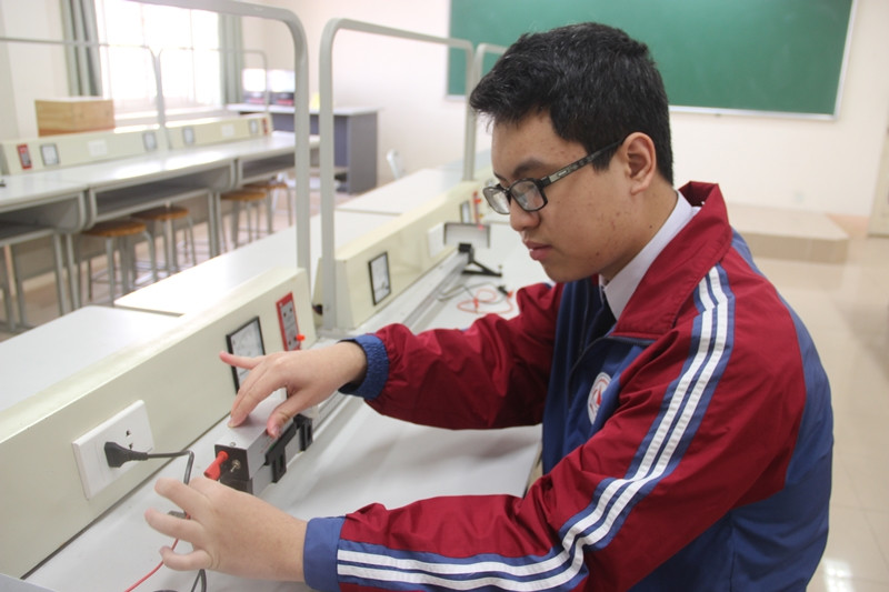 Kỳ Nam đang điều chỉnh thiết bị trong phòng thực hành Vật lý