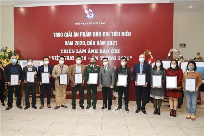 Ông Lê Quốc Minh, Chủ tịch Hội Nhà báo Việt Nam, Tổng biên tập Báo Nhân Dân trao giải A Giải thưởng Bìa báo Tết ấn tượng năm 2021 cho các đơn vị đoạt giải. Ảnh: Minh Quyết/TTXVN