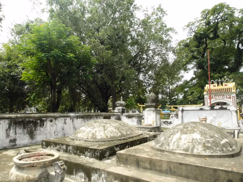 Hai ngôi mộ bằng đá, có hình mai rùa, nằm trong khuôn viên rợp bóng mát.