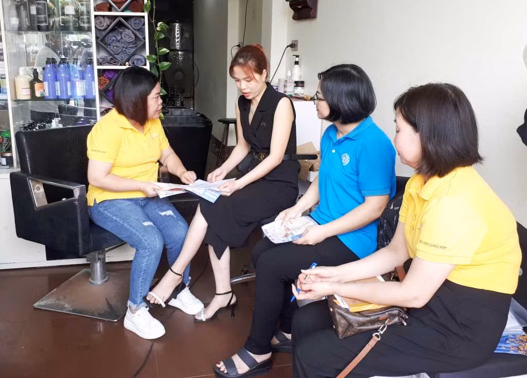 Cán bộ Bảo hiểm xã hội và Bưu điện thành phố Hạ Long tuyên truyền về bảo hiểm xã hội tự nguyện cho người dân (Ảnh: Dương Trường)