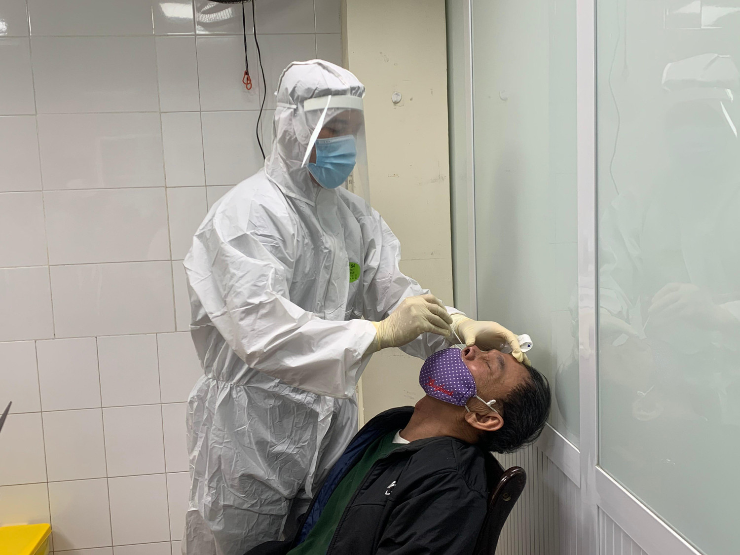 Một công dân 70 tuổi đang được lấy mẫu xét nghiệm COVID-19 trong quá trình khám sàng lọc để tham gia thử nghiệm. Ảnh:VGP/Hiền Minh
