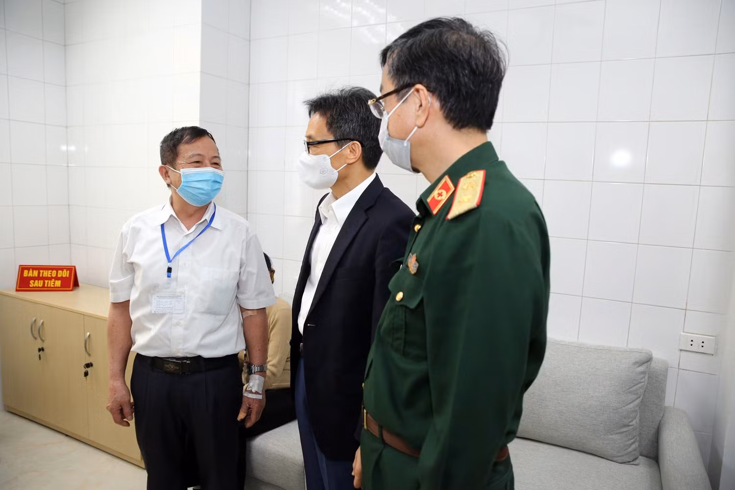 Phó Thủ tướng Vũ Đức Đam trò chuyện với một tình nguyện viên cao tuổi đang theo dõi sau tiêm. Ảnh: VGP/Đình Nam