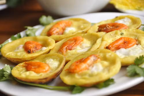 2. Bánh khọt Bánh trứng rồng, hay còn gọi là bánh khọt là món bánh dễ làm và rất quen thuộc với người dân Việt Nam, đặc biệt ở Nam Bộ. Bánh được làm từ bột gạo nên thành phần bánh chủ yếu là tinh bột và một ít chất béo từ nước cốt dừa. Bánh được bày lên đĩa cùng với rau thơm các loại, cải xà lách, dưa leo và một chén nước chấm chua ngọt tạo cảm giác hấp dẫn cho mọi người dù chỉ mới nhìn qua. 2. Bánh khọt Bánh trứng rồng, hay còn gọi là bánh khọt là món bánh dễ làm và rất quen thuộc với người dân Việt Nam, đặc biệt ở Nam Bộ. Bánh được làm từ bột gạo nên thành phần bánh chủ yếu là tinh bột và một ít chất béo từ nước cốt dừa. Bánh được bày lên đĩa cùng với rau thơm các loại, cải xà lách, dưa leo và một chén nước chấm chua ngọt tạo cảm giác hấp dẫn cho mọi người dù chỉ mới nhìn qua.