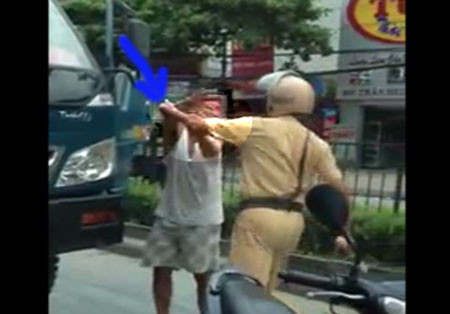 Người mặc sắc phục CSGT liên tiếp ra đòn về lái xe. (ảnh cắt từ video)