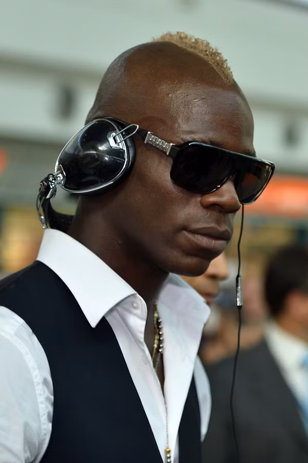 Balotelli gây ấn tượng với cặp kính đen và đeo headphone