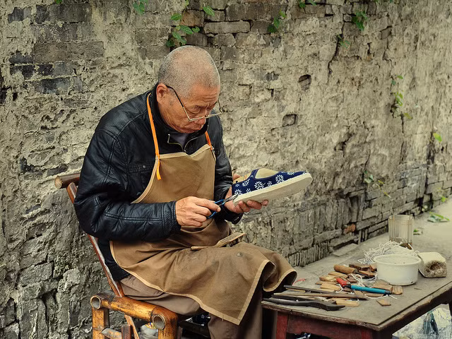 Một người thợ đóng giày ngồi gọn trong 1 con phố ở Bắc Kinh cũng có thể là một "điệp viên tình báo chống khủng bố", hình minh họa.