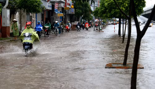Xe máy đi trên vỉa hè để tránh nước sâu.