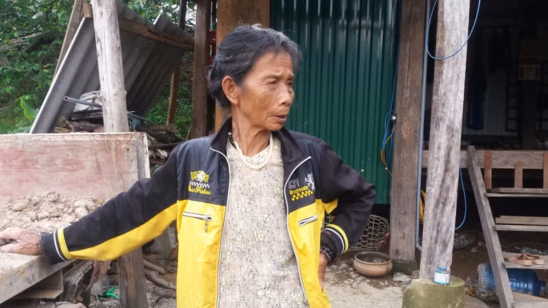Bà Nguyễn Thị Điu kể lại việc con trai phá vách nhà sàn, cõng mẹ chạy lũ. Ảnh: B.S