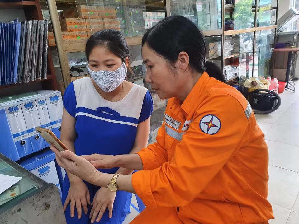 Công nhân Điện lực Mai Châu hướng dẫn khách hàng dịch vụ thanh toán tiền điện không dùng tiền mặt. Công nhân Điện lực Mai Châu hướng dẫn khách hàng dịch vụ thanh toán tiền điện không dùng tiền mặt.