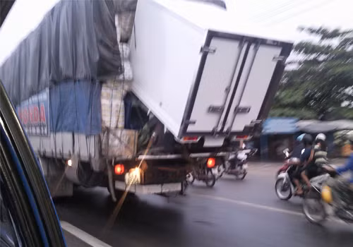 Chiếc xe trên thùng sắp rớt ra, gây nguy hiểm cho người đi sau. Chụp tại quốc lộ 1A. Ảnh: Đặng Quốc Trịnh.