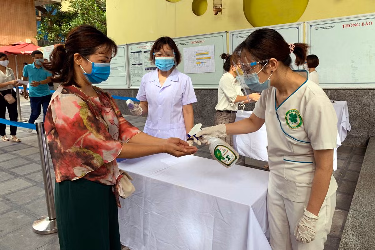 Diễn tập đo thân nhiệt sát khuẩn tay các thí sinh đến dự thi. Ảnh: Tùng Dương.