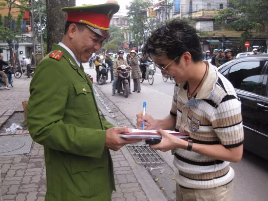 Có vẻ như Mr Đàm viết thêm điều gì đó khiến anh công an vui cười tít mắt...