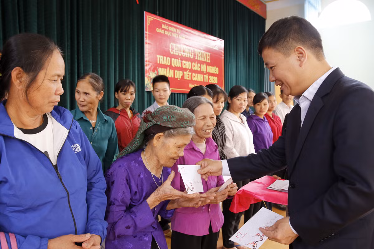 Nhà báo Nguyễn Tiến Bình - Tổng biên tập Báo điện tử Giáo dục Việt Nam trao tận tay các hộ nghèo của xã Hùng Xuyên. Ảnh: Tùng Dương.