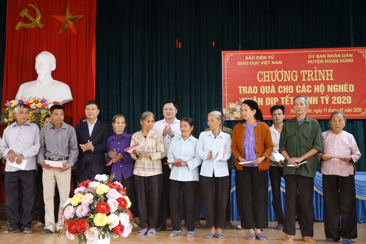 Ông Nguyễn Anh Hùng - phó Chủ tịch Ủy ban nhân dân huyện Đoan Hùng, tỉnh Phú Thọ và Nhà báo Nguyễn Tiến Bình - Tổng biên tập Báo điện tử Giáo dục Việt Nam với các hộ nghèo của xã Hùng Xuyên. Ảnh: Tùng Dương.
