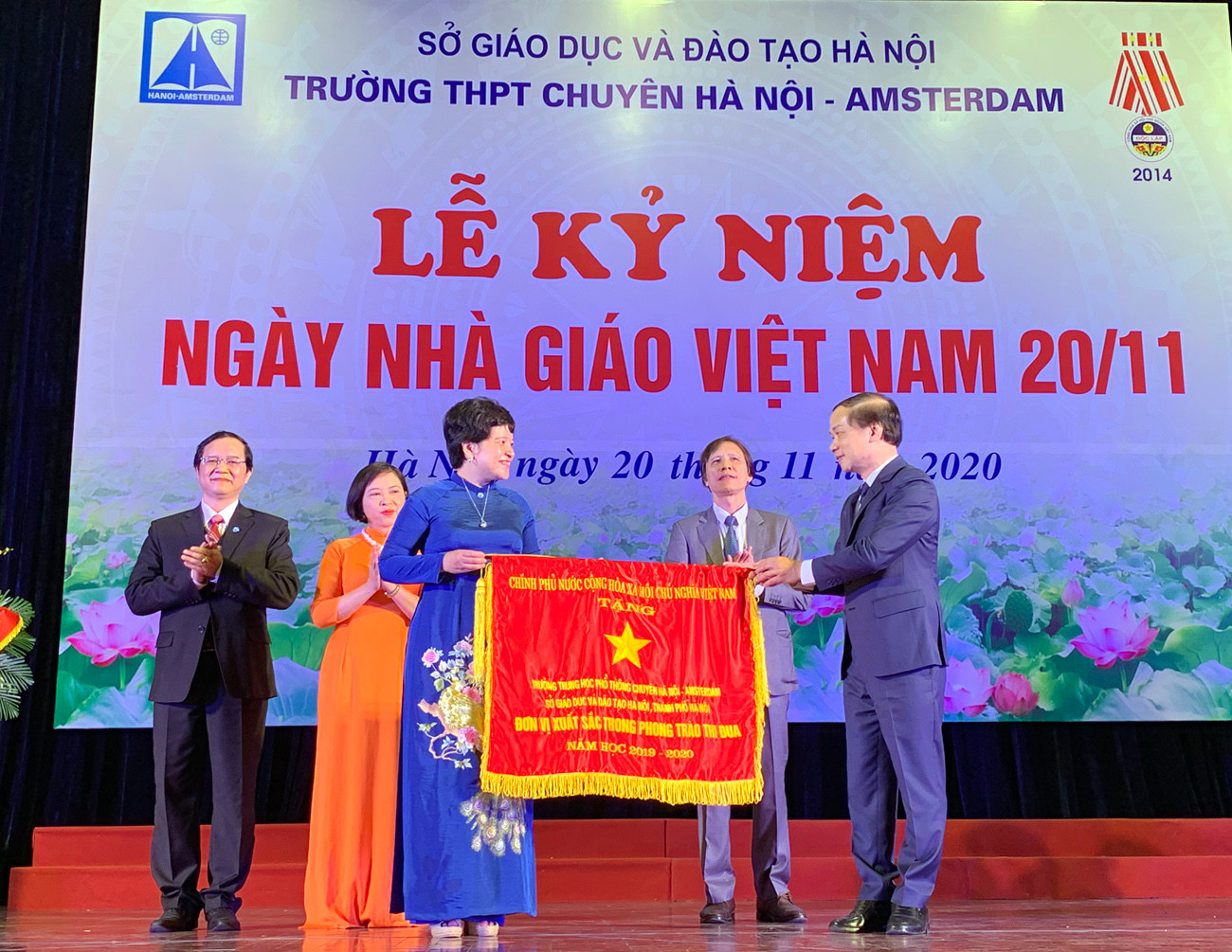 Ông Phạm Tất Thắng (ngoài cùng bên phải) - Phó Chủ nhiệm Ủy ban Văn hóa, Thanh niên, Thiếu niên và Nhi đồng của Quốc hội đang trao tặng Cờ thi đua của Chính phủ cho tập thể cán bộ giáo viên Trường trung học phổ thông Chuyên Hà Nội - Amsterdam tại lễ kỷ niệm. Ảnh: Tùng Dương.