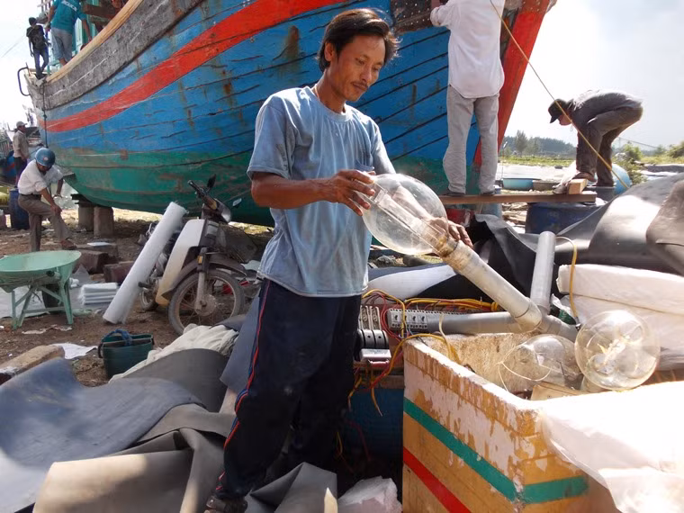 Ngư dân Huỳnh Văn Lắm đang gỡ dàn đèn câu cá ngừ đại dương xuống