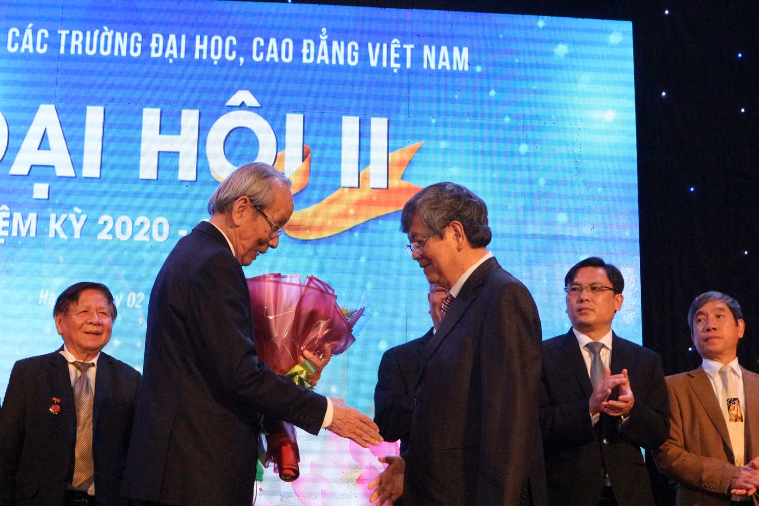 Giáo sư Trần Hồng Quân - Chủ tịch Hiệp hội Các trường đại học, cao đẳng Việt Nam nhiệm kỳ 2015-2020 tặng hoa chúc mừng tân Chủ tịch Vũ Ngọc Hoàng (ảnh: Tùng Dương)