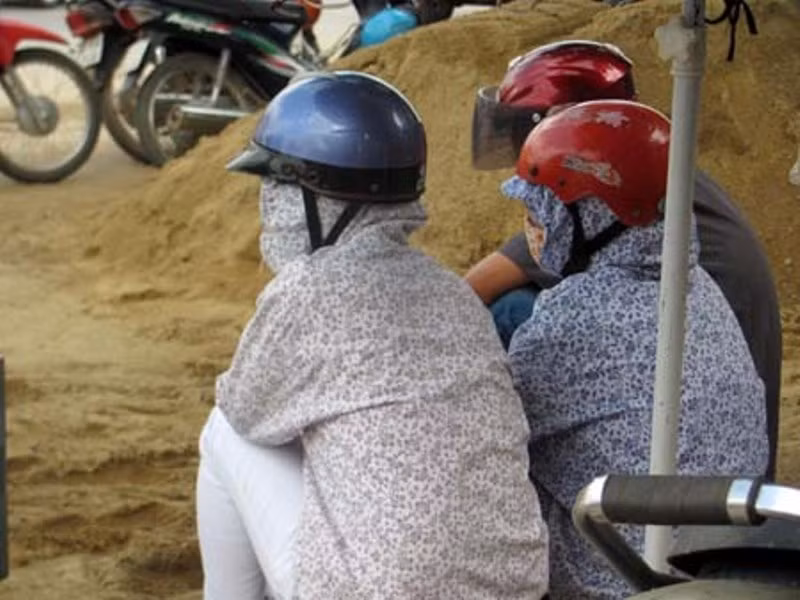 Thời tiết oi bức của tháng 6 khiến nhiều phụ huynh “ngụy trang” ngồi chờ con.