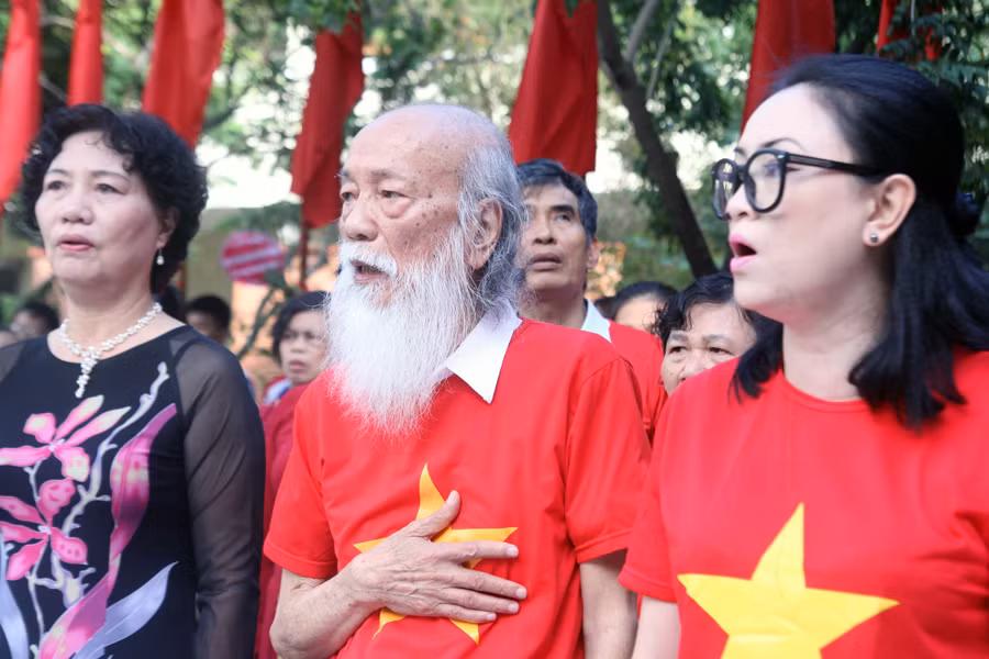 Nhà giáo Văn Như Cương cùng các thầy cô và trò oai hùng hát Quốc ca.