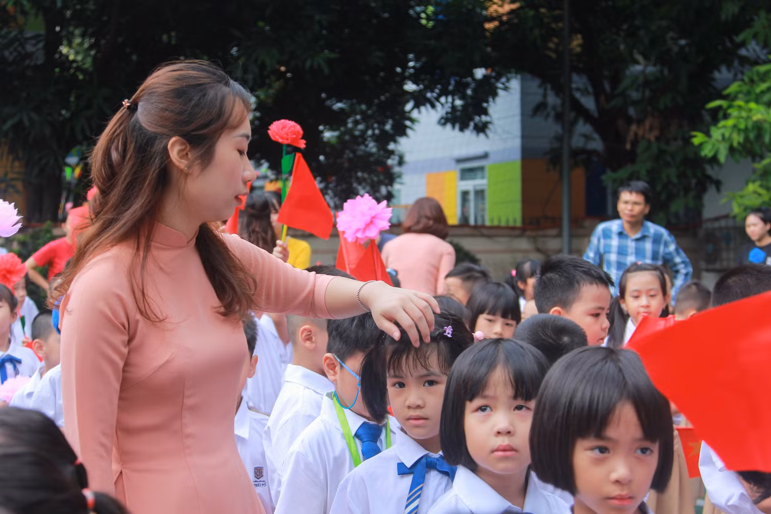 Giáo viên chủ nhiệm vén mái tóc của học trò mướt mồ hôi. Giáo viên chủ nhiệm vén mái tóc của học trò mướt mồ hôi.