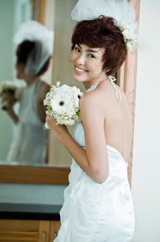 Tăng Thanh Hà có mái tóc tomboy cá tính, vì vậy khi sắm vai nàng dâu về nhà chồng, Tăng Thanh Hà sử dụng gel tạo kiểu giúp mái tóc trở nên nghịch ngợm và lạ mắt. Lựa thêm bông voan tết hoa hồng làm điệu cho mái tóc, cô dâu xinh đẹp đây rồi. (Ảnh: dantri)