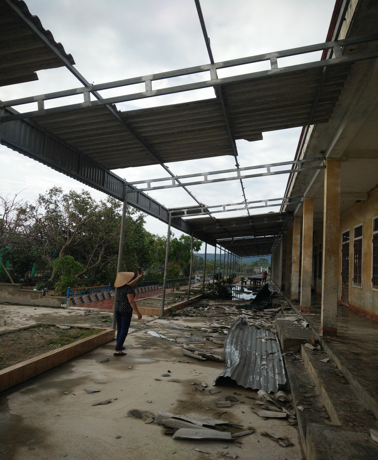 Mái hiên che nắng trước lớp học và dãy phòng hành chính bị bay tấm lợp