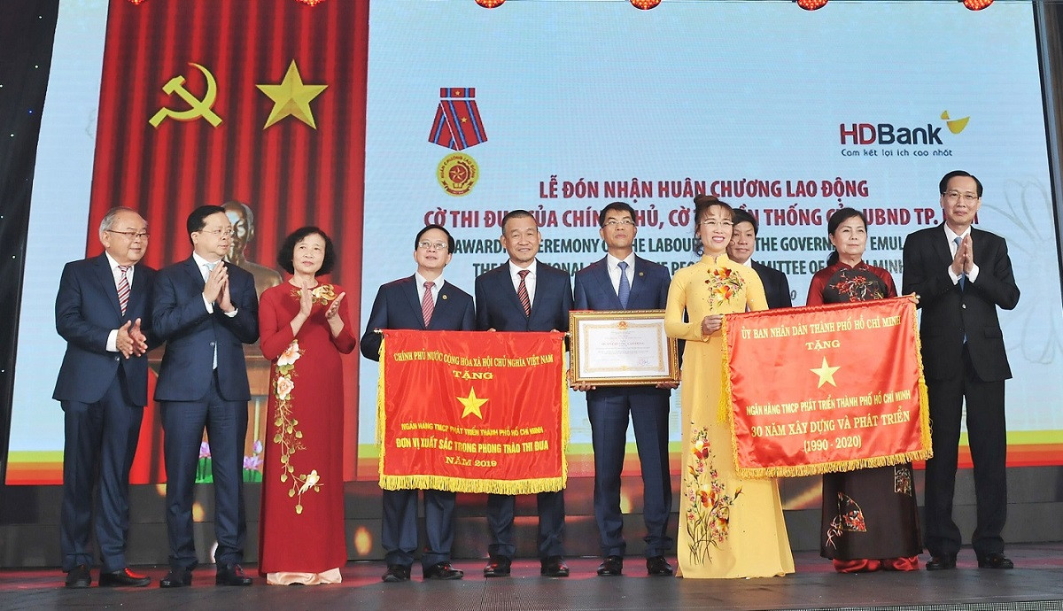 Ông Lê Thanh Liêm - Ủy viên Ban thường vụ Thành ủy, Phó Chủ tịch thường trực Ủy ban nhân dân Thành phố Hồ Chí Minh trao Cờ Truyền thống cho Ban Lãnh đạo HDBank.