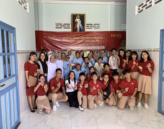 Học sinh iSchool Long An, đại diện NHG trao tặng tiền, quà cho Nhà Dưỡng lão tình thương Thanh Bình (ảnh: NHG)