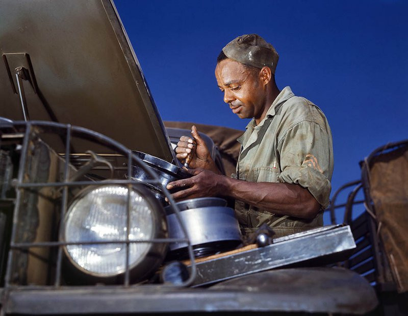 Một công nhân da màu làm việc với một chiếc xe tải quân sự tại Fort Knox, Kentucky, 1942.