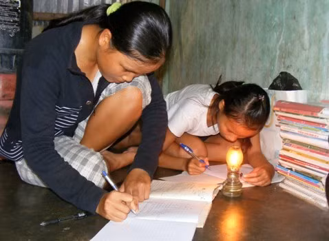 Nhà không bàn ghế, đèn điện nên các em phải học dưới ánh đèn dầu. Nhà không bàn ghế, đèn điện nên các em phải học dưới ánh đèn dầu.