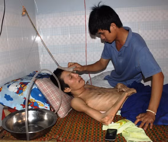 Không phải là bà con họ hàng nhưng hơn 4 năm qua, em Hồ Công Danh tự nguyện chăm sóc người hàng xóm bị bại liệt toàn thân.