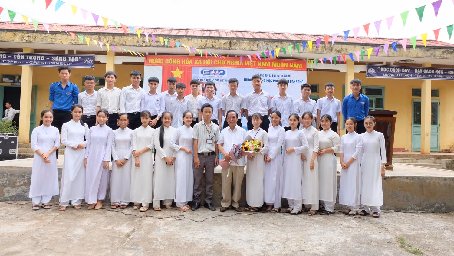 Giáo sư Nguyễn Lân Dũng chụp ảnh với các em học sinh trong trường. (Ảnh: LC)