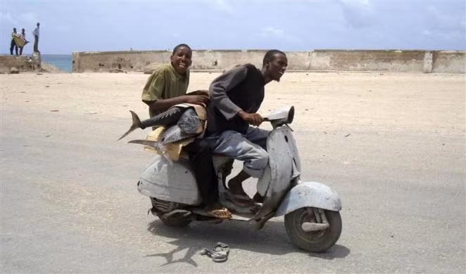 Hai thanh niên Somalia dùng xe máy chở cá kiếm tại nam Mogadishu ngày 16/8/2010.