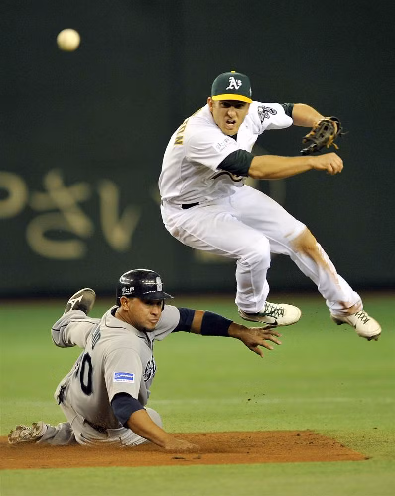 Cầu thủ Cliff Pennington của đội Oakland Athletics ném bóng khi Miguel Olivo của đội Seattle Mariners bắt trượt trong hiệp 2 của trận đấu mở màn mùa giải bóng chày Major League tại sân Tokyo Dome ở Tokyo, Nhật Bản ngày 28/3. Cầu thủ Cliff Pennington của đội Oakland Athletics ném bóng khi Miguel Olivo của đội Seattle Mariners bắt trượt trong hiệp 2 của trận đấu mở màn mùa giải bóng chày Major League tại sân Tokyo Dome ở Tokyo, Nhật Bản ngày 28/3.