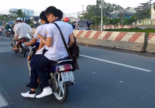 Học sinh chở 3 không đội mũ bảo hiểm. Ảnh: Nguyen Phuoc Thai Hoc. Học sinh chở 3 không đội mũ bảo hiểm. Ảnh: Nguyen Phuoc Thai Hoc.