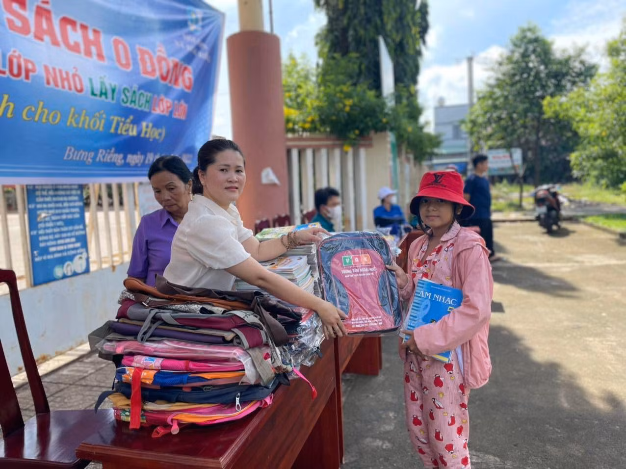 Chị Mai Thanh Kiều, Chủ tịch Hội Liên hiệp phụ nữ xã Bưng Riềng tặng cặp, đồ dùng học tập cho học sinh.