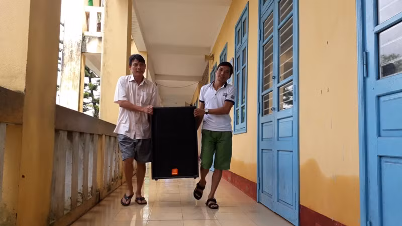 Hai thầy trường Tiểu học Quảng Phước mang loa về lại lớp sau khi được kê lên vì lũ. Hai thầy trường Tiểu học Quảng Phước mang loa về lại lớp sau khi được kê lên vì lũ.
