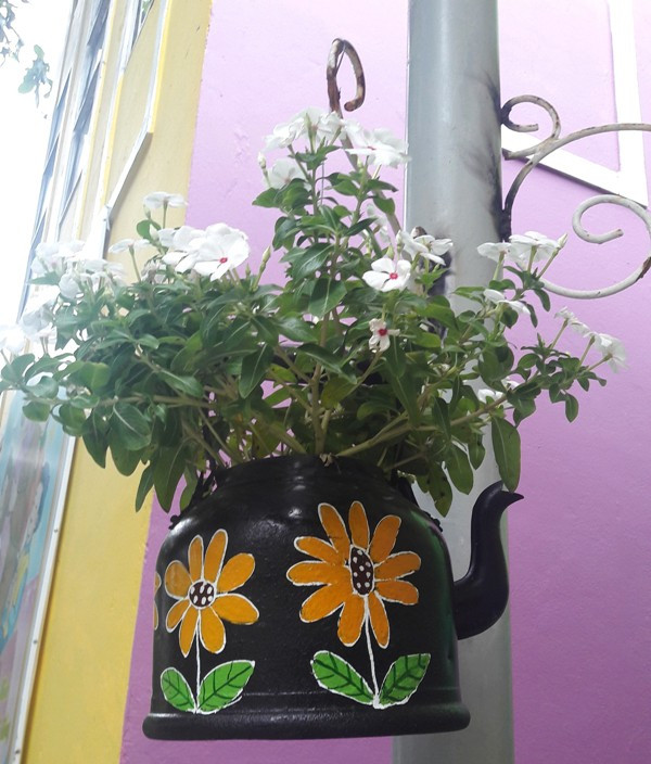 Một chiếc ấm hỏng đã được tô vẽ, tái chế thành một "chậu hoa" đặc sắc.