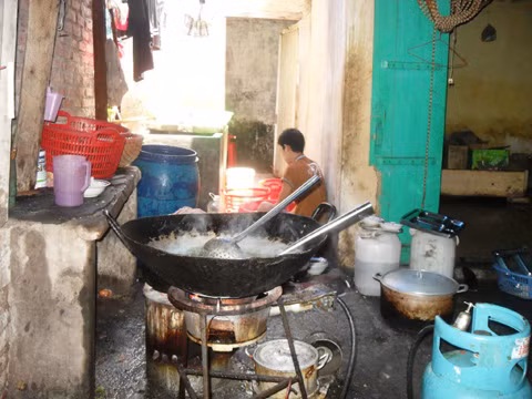 Trong khu vực bếp kiêm luôn nhiều chức năng: vừa chế biến, vừa rửa bát, cách đó là cửa nhà vệ sinh còn bỏ ngỏ, dưới cái nền đất nhầy nhụa nước bẩn. Ảnh VNE
