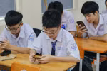 Học sinh Trường trung học phổ thông Bùi Thị Xuân làm bài kiểm tra trên máy tính, điện thoại tại lớp. Ảnh: NTCC.