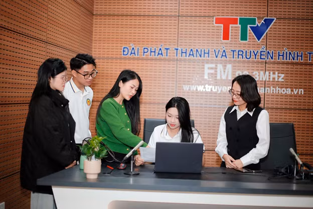 Sinh viên được hướng dẫn trải nghiệm phòng thu âm các chương trình bản tin phát thanh. Ảnh: HDU